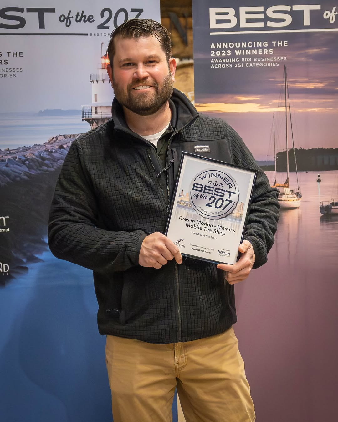 Charlie holding a Best of the 207 award for Tires in Motion
