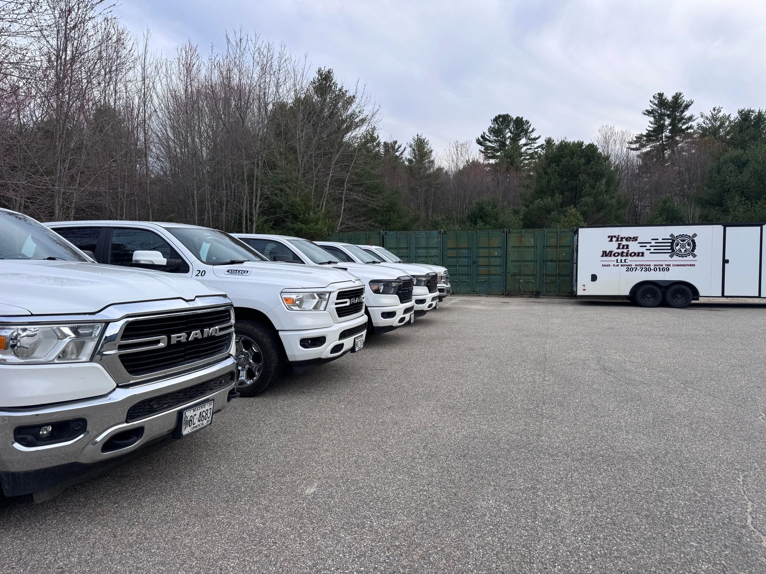 Tires in Motion’s service trailer on location with a fleet of work trucks