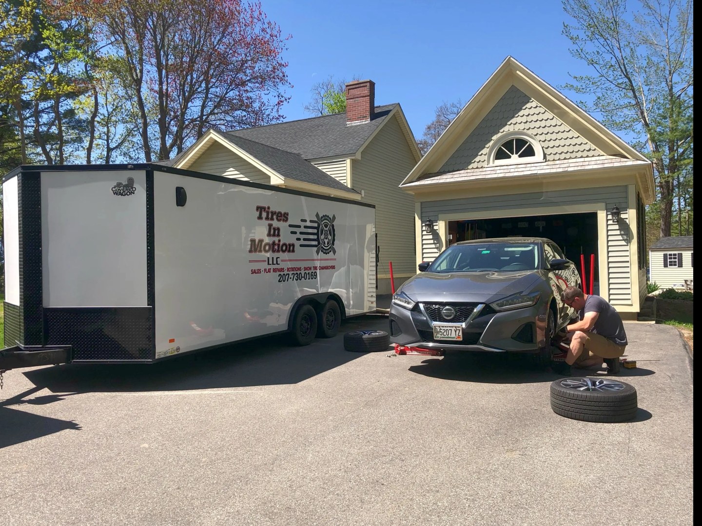 Tires in Motion’s mobile tire shop and technician installing tires in a customer’s driveway